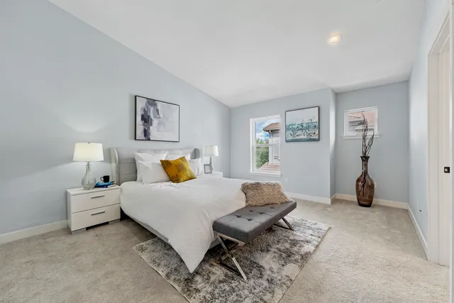 a spacious bedroom with a bed and a lamp