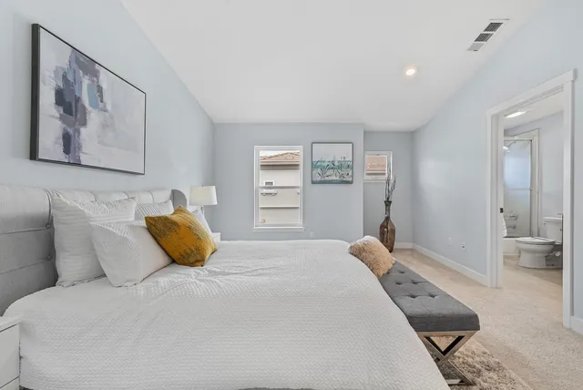 a bedroom with a bed and a painting on the wall