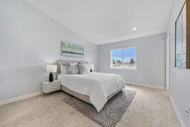 a bedroom with a bed and painting on the wall