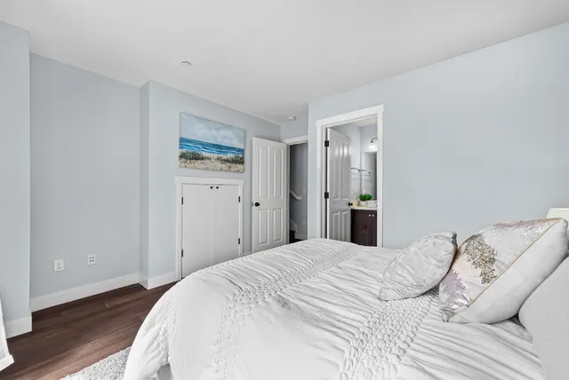 a bedroom with a bed and a painting on the wall