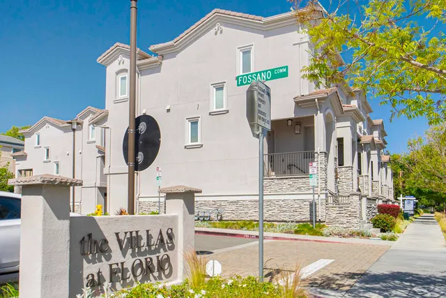 an aerial view of residential houses with outdoor space and parking