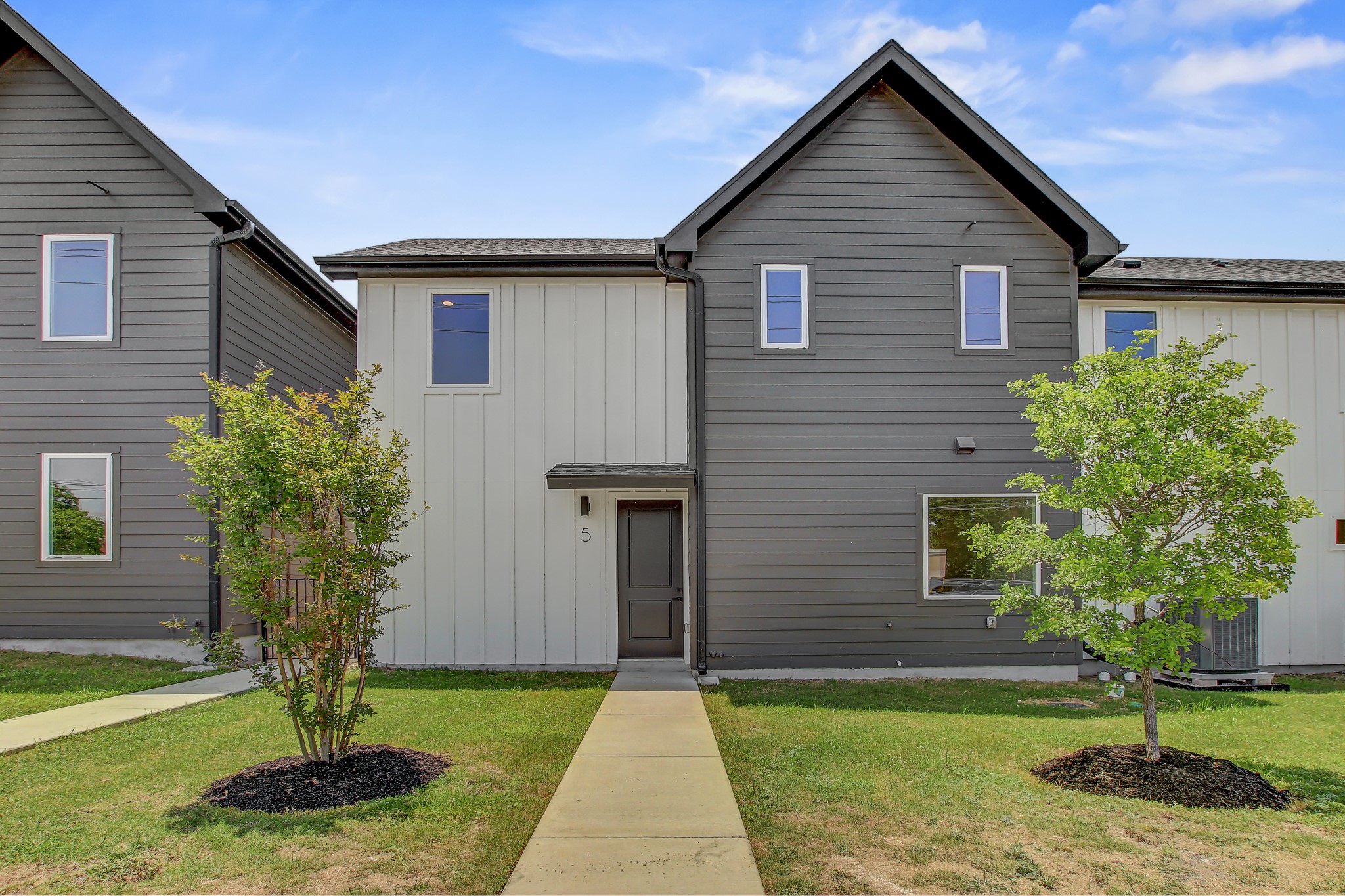4127 East 12th Street, Unit 5 Austin, TX 78721 - Photo 31 of 33 View of front facade with board and batten siding and a front yard