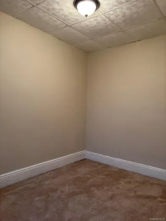 a view of empty room with cabinet and flat screen tv