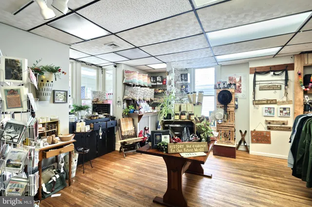 a kitchen with stainless steel appliances granite countertop a stove top oven a dining table and chairs with wooden floor