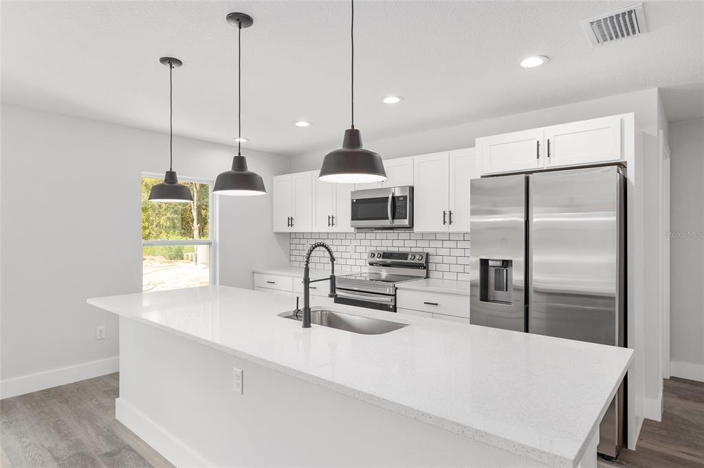 15769 Southwest 14th Street Ocala, FL 34481 - Photo 14 of 46 a kitchen with stainless steel appliances a sink a refrigerator a counter space and a window