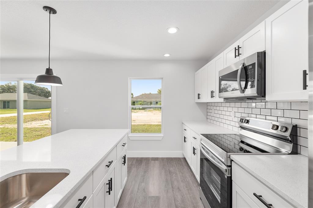 15769 Southwest 14th Street Ocala, FL 34481 - Photo 18 of 46 a kitchen that has a sink a stove and cabinets
