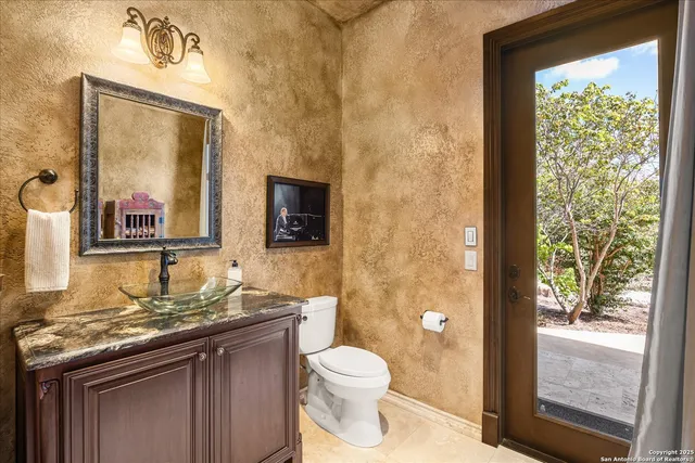 a bathroom with a granite countertop sink and large window