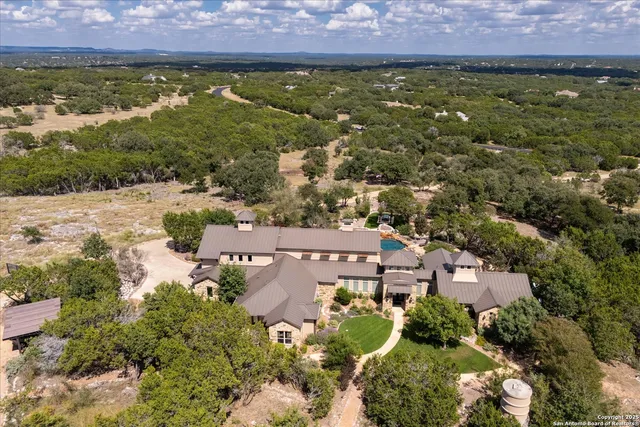 an aerial view of residential houses with outdoor space and trees