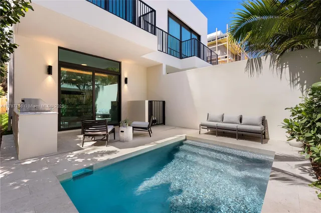 a view of a house with backyard and sitting area