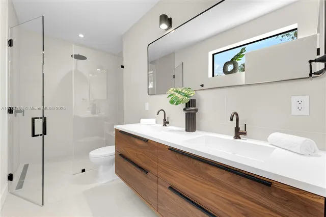 a bathroom with a granite countertop sink a toilet and shower
