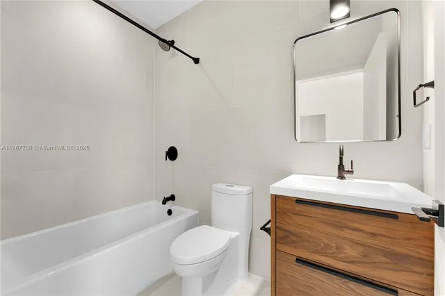 a bathroom with a sink toilet vanity and tub