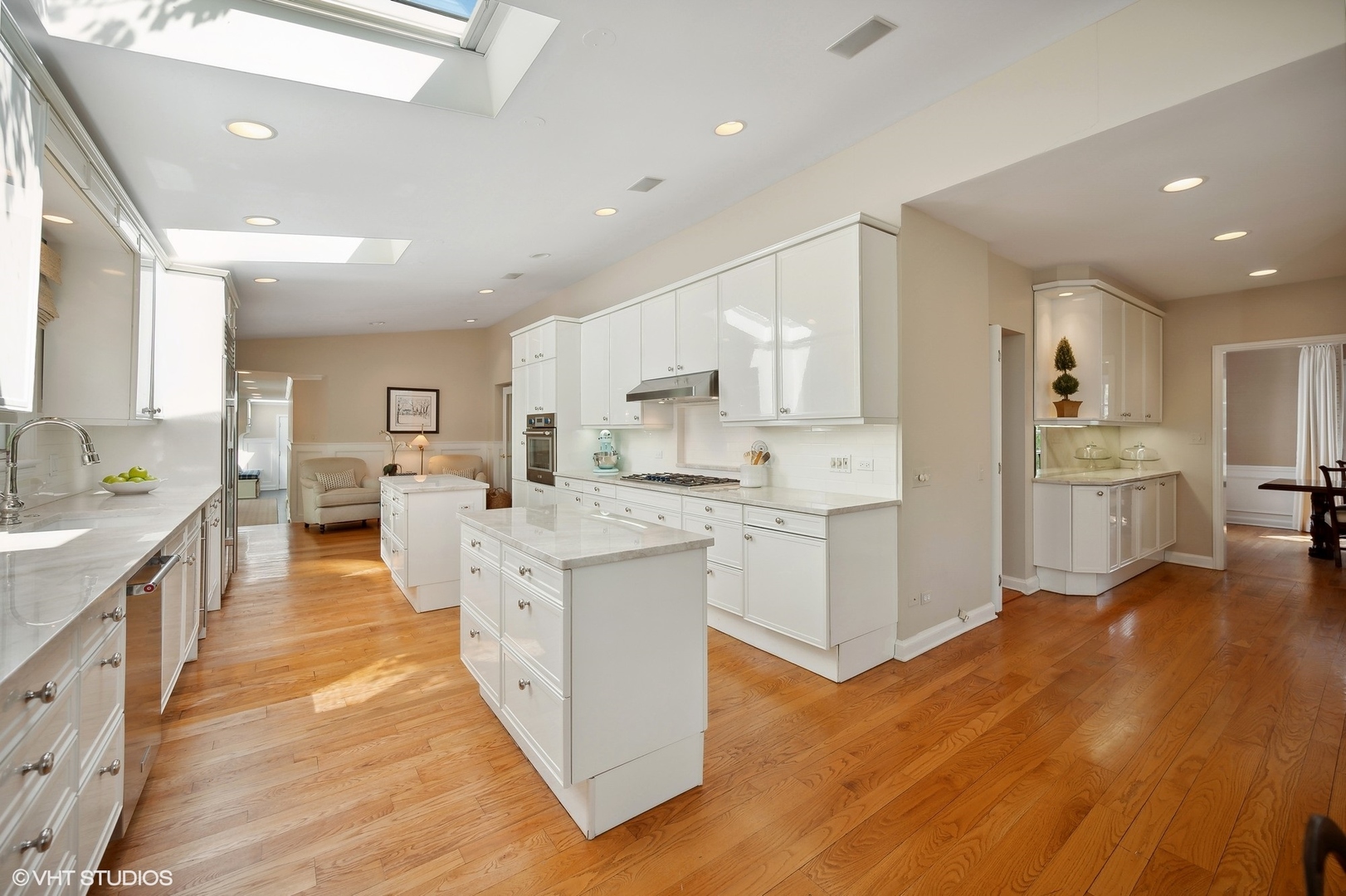1744 Ridgewood Lane East Glenview, IL 60025 - Photo 13 of 48 a large white kitchen with a large counter top a sink stainless steel appliances and cabinets