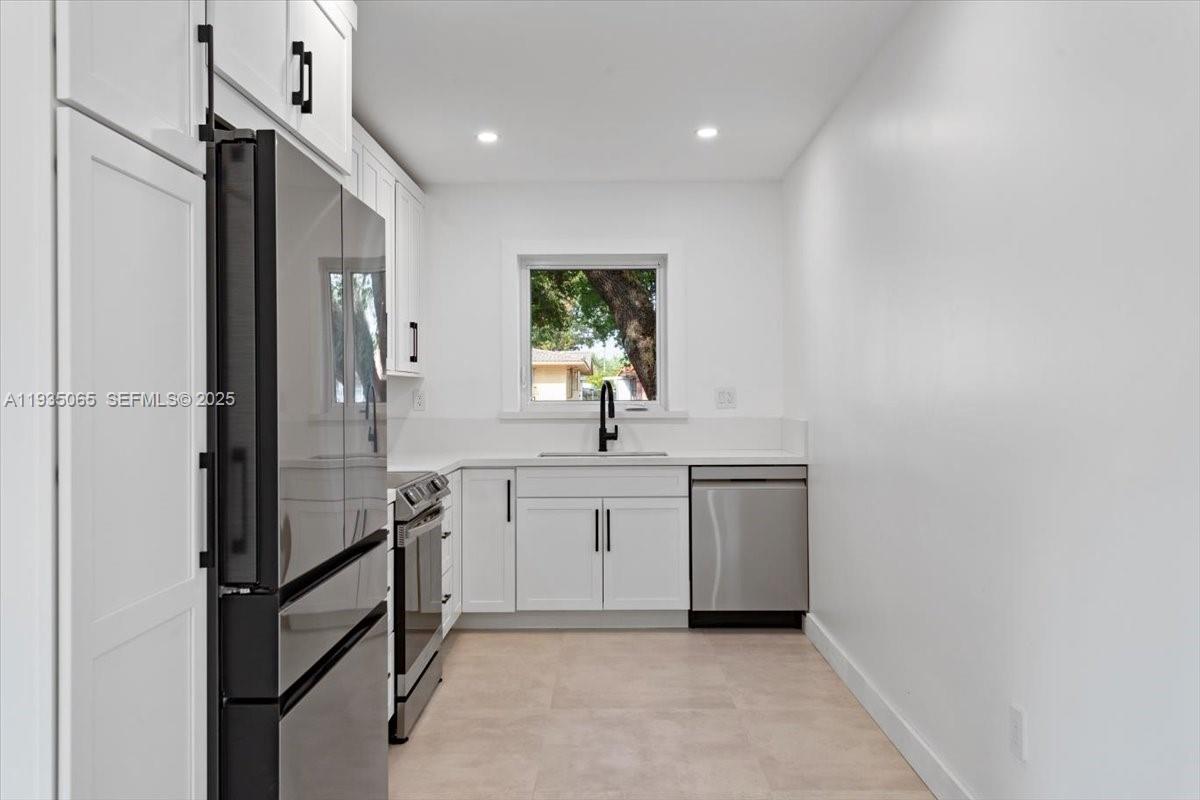 3260 Northwest 9th Street Miami, FL 33125 - Photo 11 of 33 a kitchen with white cabinets and white appliances