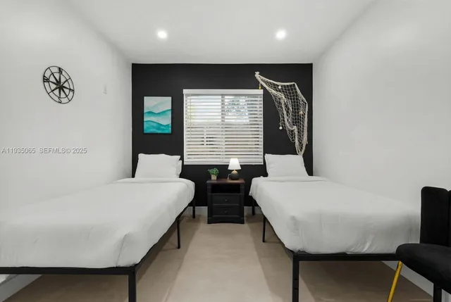 a bedroom with two beds and a potted plant