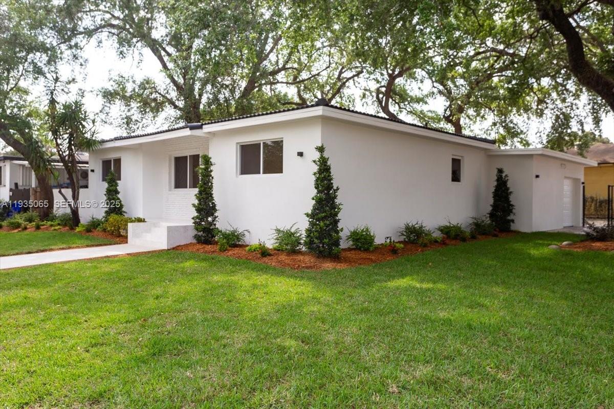 3260 Northwest 9th Street Miami, FL 33125 - Photo 2 of 33 a backyard of a house with potted plants and large tree