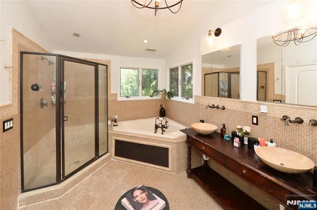 a bathroom with a tub sink and mirror