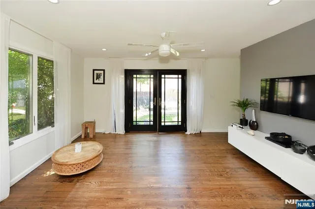 a living room with a large window and wooden floor