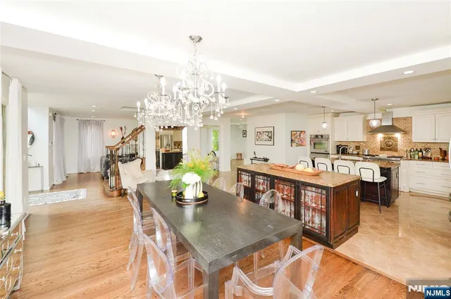 a living room with dining table and a chandelier