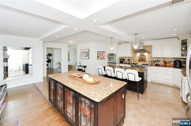 a open kitchen with stainless steel appliances kitchen island granite countertop a table and chairs