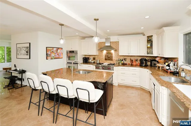 a large kitchen with a table chairs refrigerator and cabinets