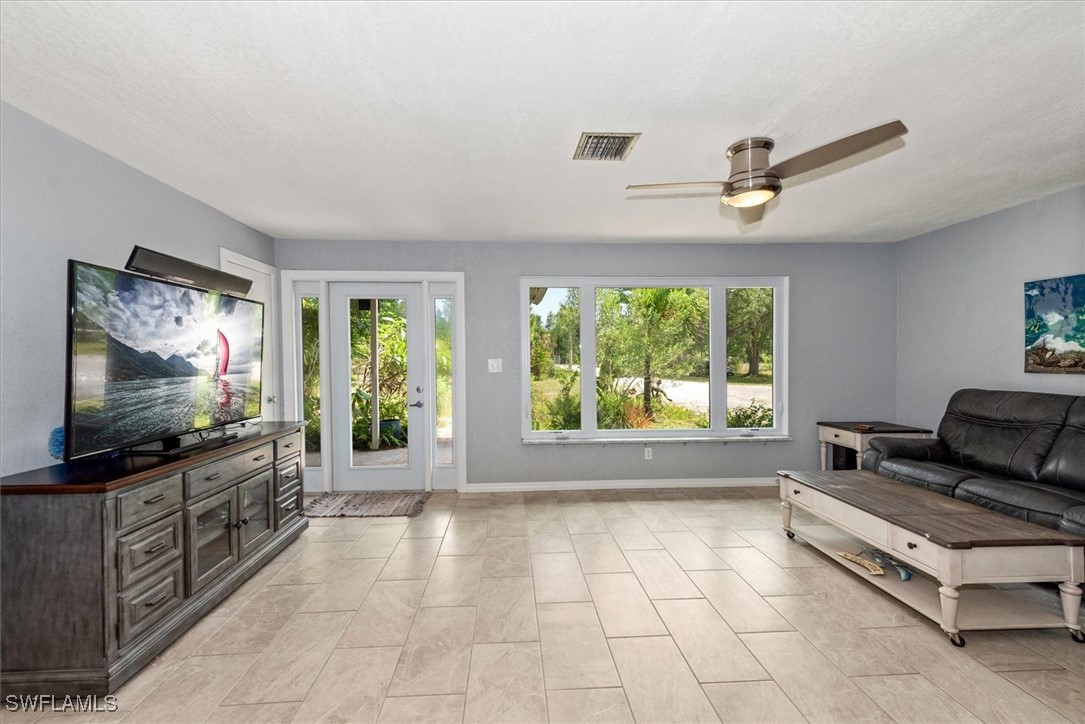 13951 Rod And Gun Club Road Fort Myers, FL 33913 - Photo 14 of 49 a living room with furniture and a flat screen tv