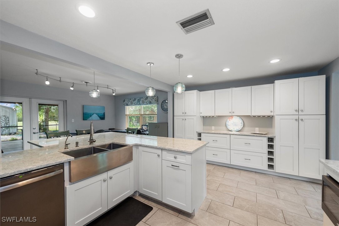 13951 Rod And Gun Club Road Fort Myers, FL 33913 - Photo 17 of 49 a kitchen with white cabinets appliances and a sink