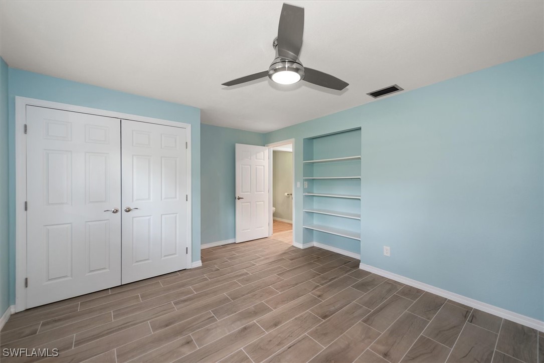 13951 Rod And Gun Club Road Fort Myers, FL 33913 - Photo 25 of 49 a view of an empty room with a ceiling fan wooden floor and window