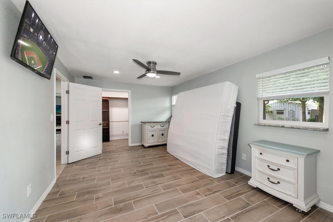 13951 Rod And Gun Club Road Fort Myers, FL 33913 - Photo 29 of 49 a view of a bedroom with furniture and wooden floor