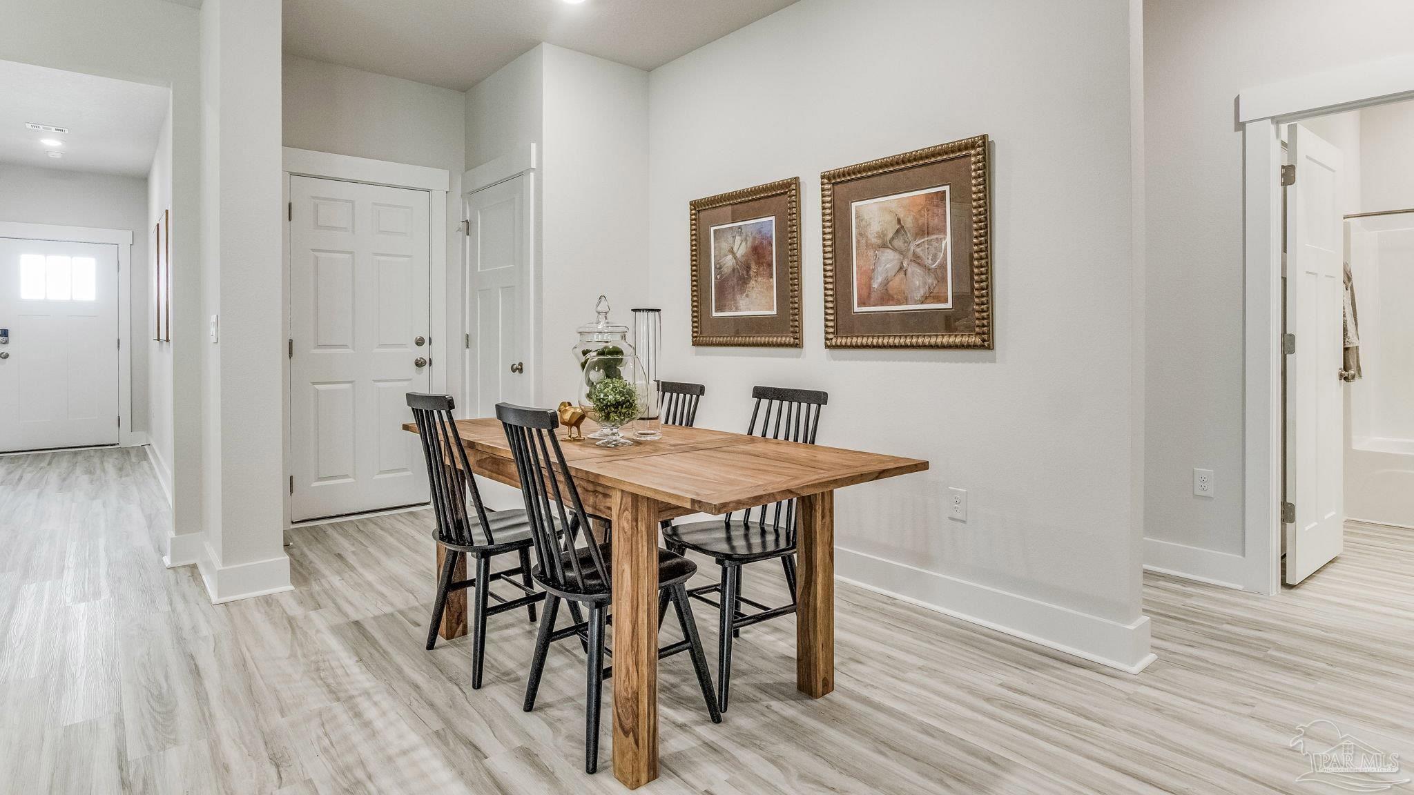 5856 Dove Nest Road Gulf Breeze, FL 32563 - Photo 11 of 33 a view of a dining room with furniture and wooden floor