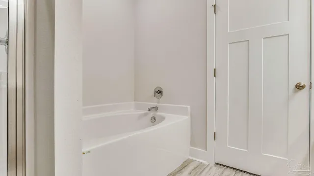 a white bath tub sitting next to a white wooden tub