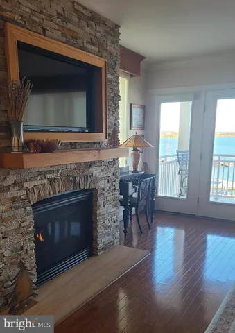 a living room with a fireplace a flat screen tv and a large window