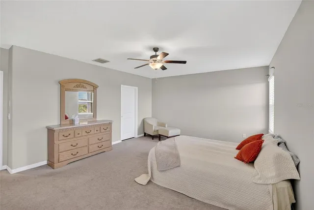 a bedroom with a bed and a ceiling fan in it