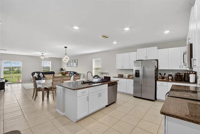 a kitchen with granite countertop a stove sink and refrigerator