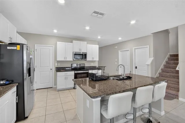 a living room with furniture a fireplace and a chandelier