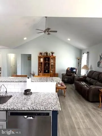 a living room with granite countertop kitchen island furniture and a wooden floor