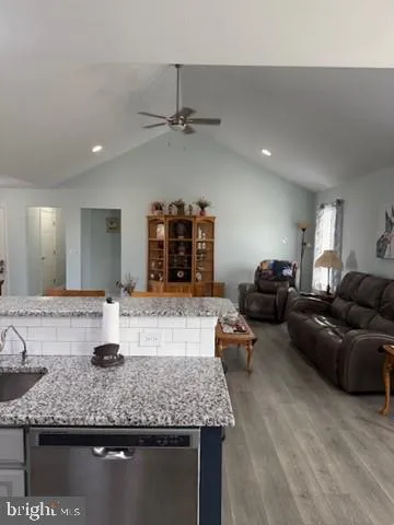 a living room with granite countertop furniture and a wooden floor