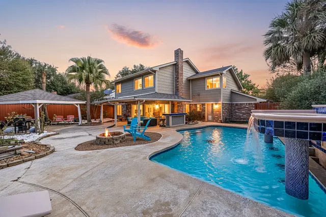 a view of a house with swimming pool and sitting area
