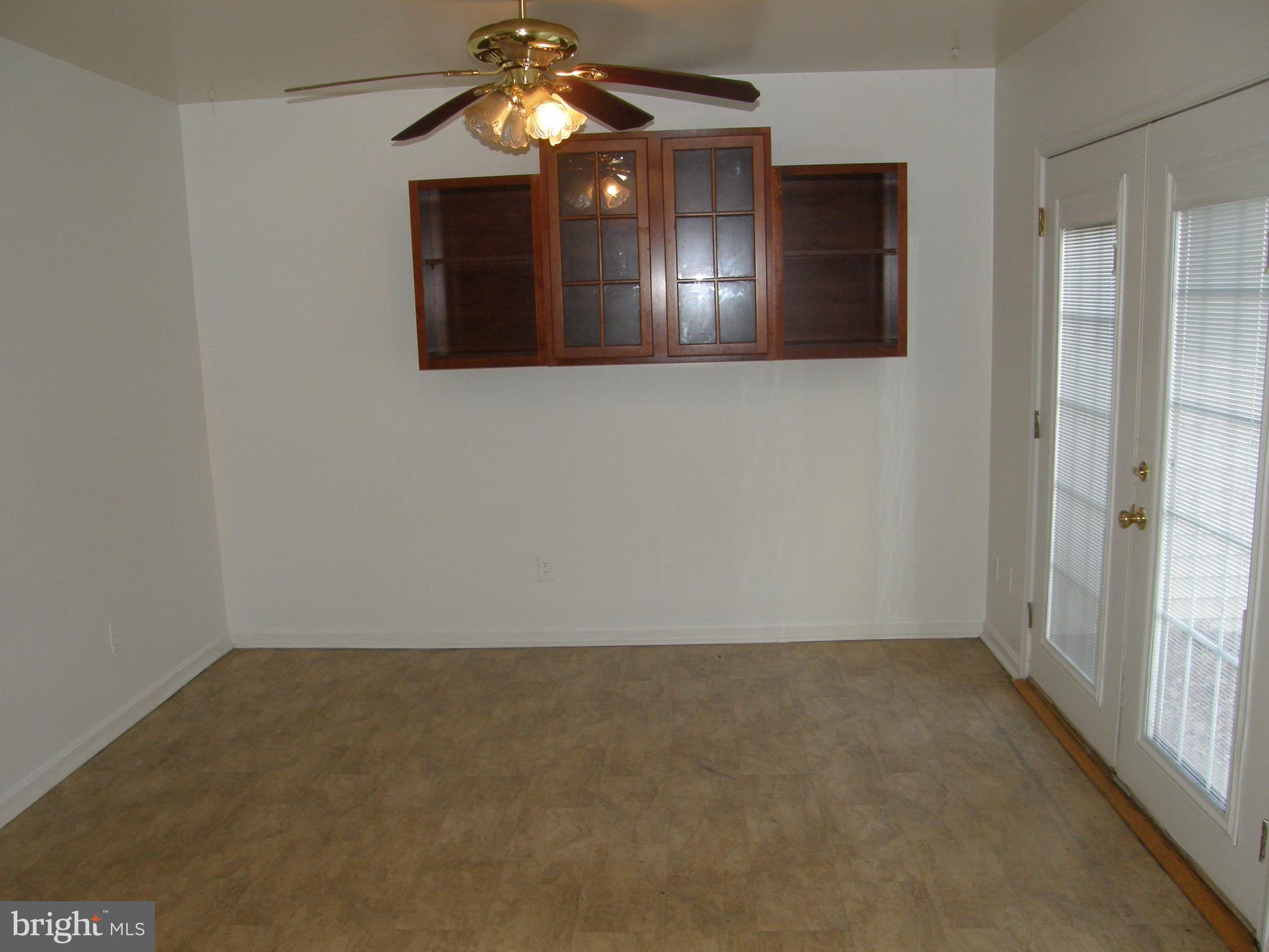 22087 Spring Valley Drive Lexington Park, MD 20653 - Photo 9 of 29 an empty room with wooden floor chandelier fan and windows
