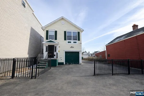a view of a house with a balcony and next to a yard