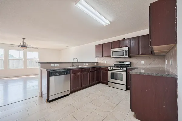 a kitchen with stainless steel appliances granite countertop a stove top oven and sink