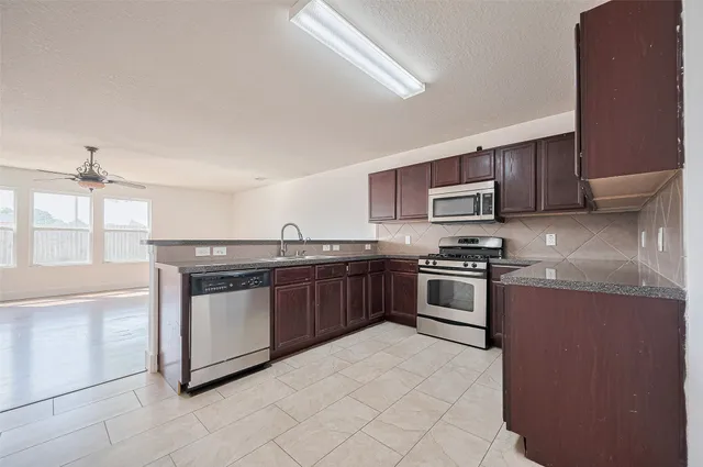 a kitchen with stainless steel appliances granite countertop a stove top oven and sink