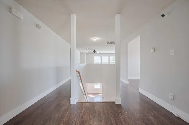 a view of a hallway with wooden floor and staircase