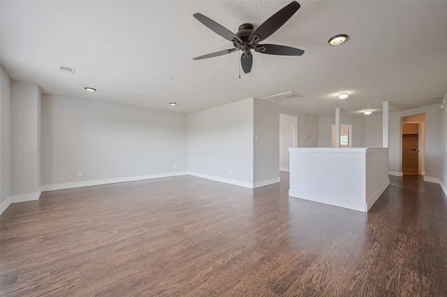 a view of a livingroom with a ceiling fan wooden floor and a ceiling fan