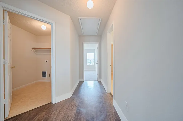 a view of a hallway with wooden floor