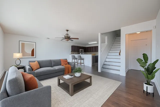 a living room with furniture potted plant and wooden floor