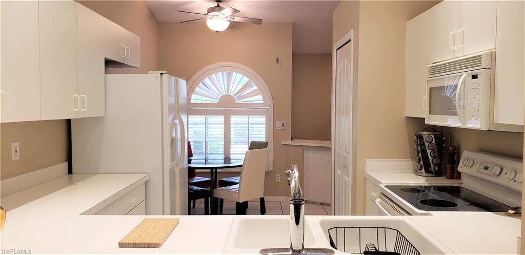 2258 Stacil Circle, Unit 1 Naples, FL 34109 - Photo 12 of 28 a kitchen with stainless steel appliances granite countertop a stove a sink and a refrigerator