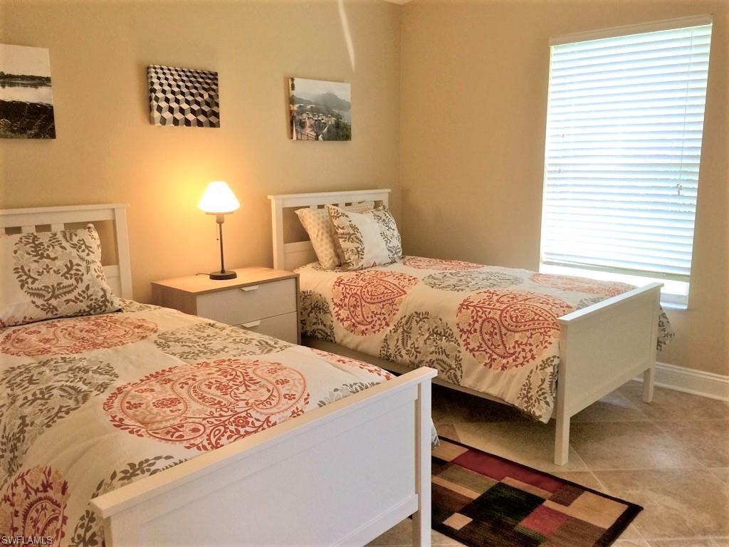 2258 Stacil Circle, Unit 1 Naples, FL 34109 - Photo 13 of 28 a bedroom with two beds and a window