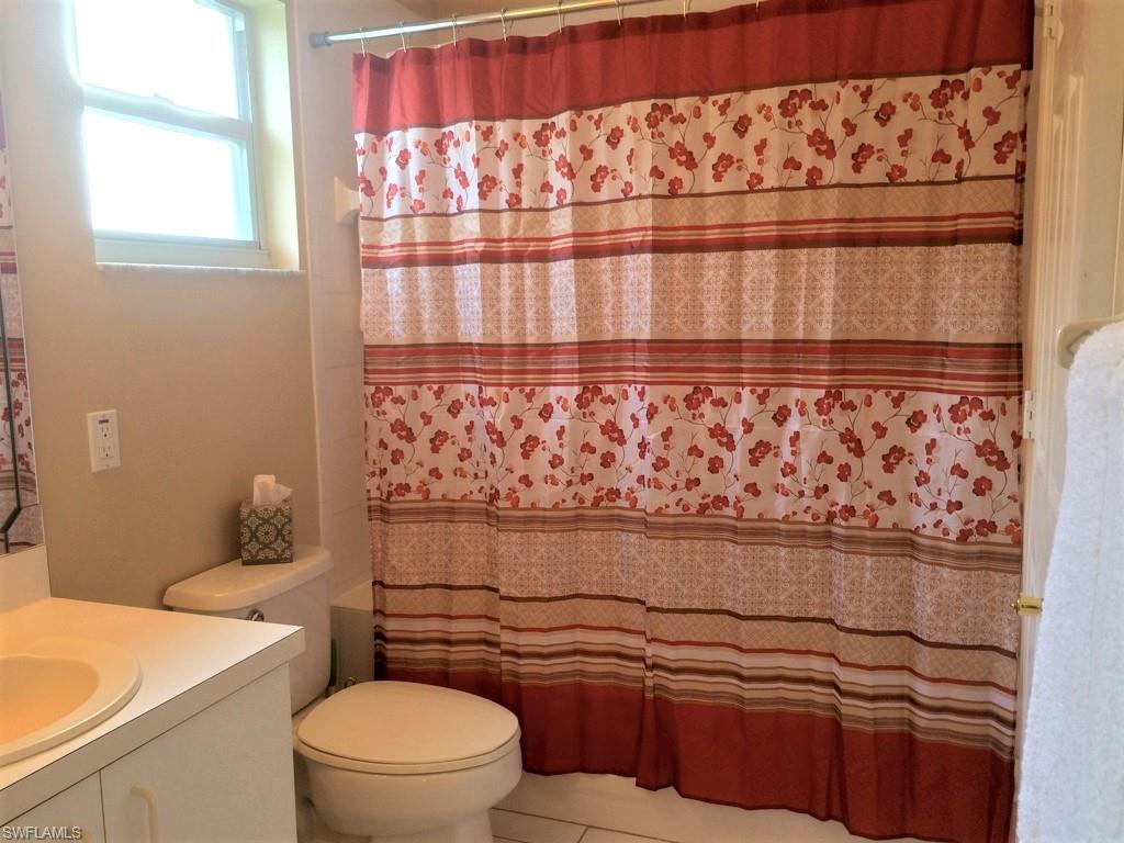 2258 Stacil Circle, Unit 1 Naples, FL 34109 - Photo 14 of 28 a bathroom with a granite countertop toilet and a sink