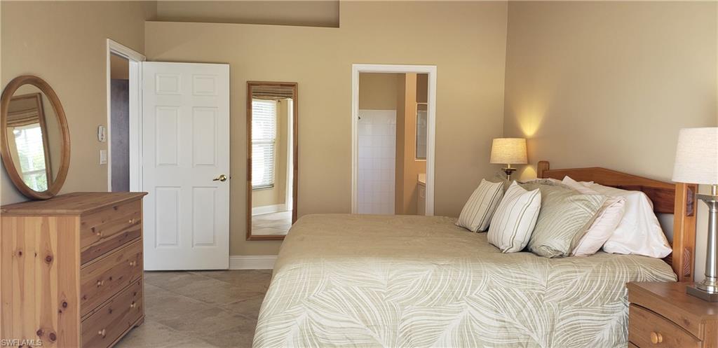2258 Stacil Circle, Unit 1 Naples, FL 34109 - Photo 16 of 28 a bedroom with a bed and a mirror