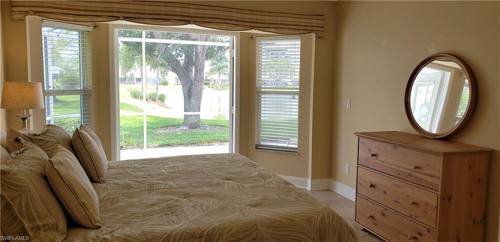 2258 Stacil Circle, Unit 1 Naples, FL 34109 - Photo 17 of 28 a bedroom with a bed and a mirror